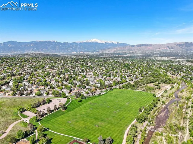 a view of a lush green field with mountains in the background