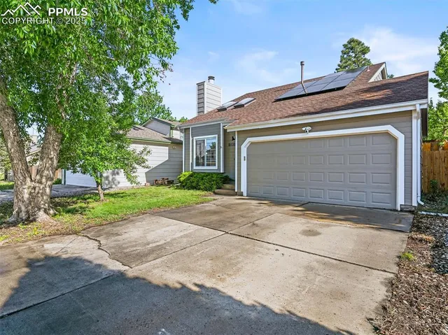 a front view of a house with a yard and a garage