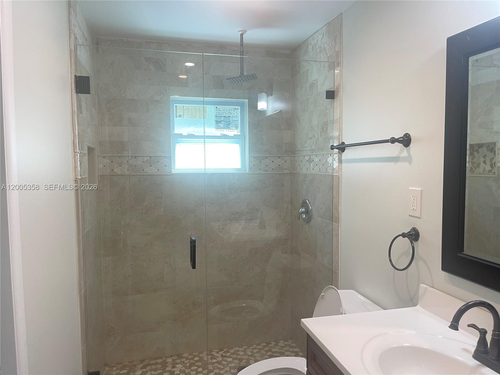 554 Northeast 74th Street, Unit 2 Miami, FL 33138 - Photo 20 of 30 a bathroom with a shower sink mirror and toilet