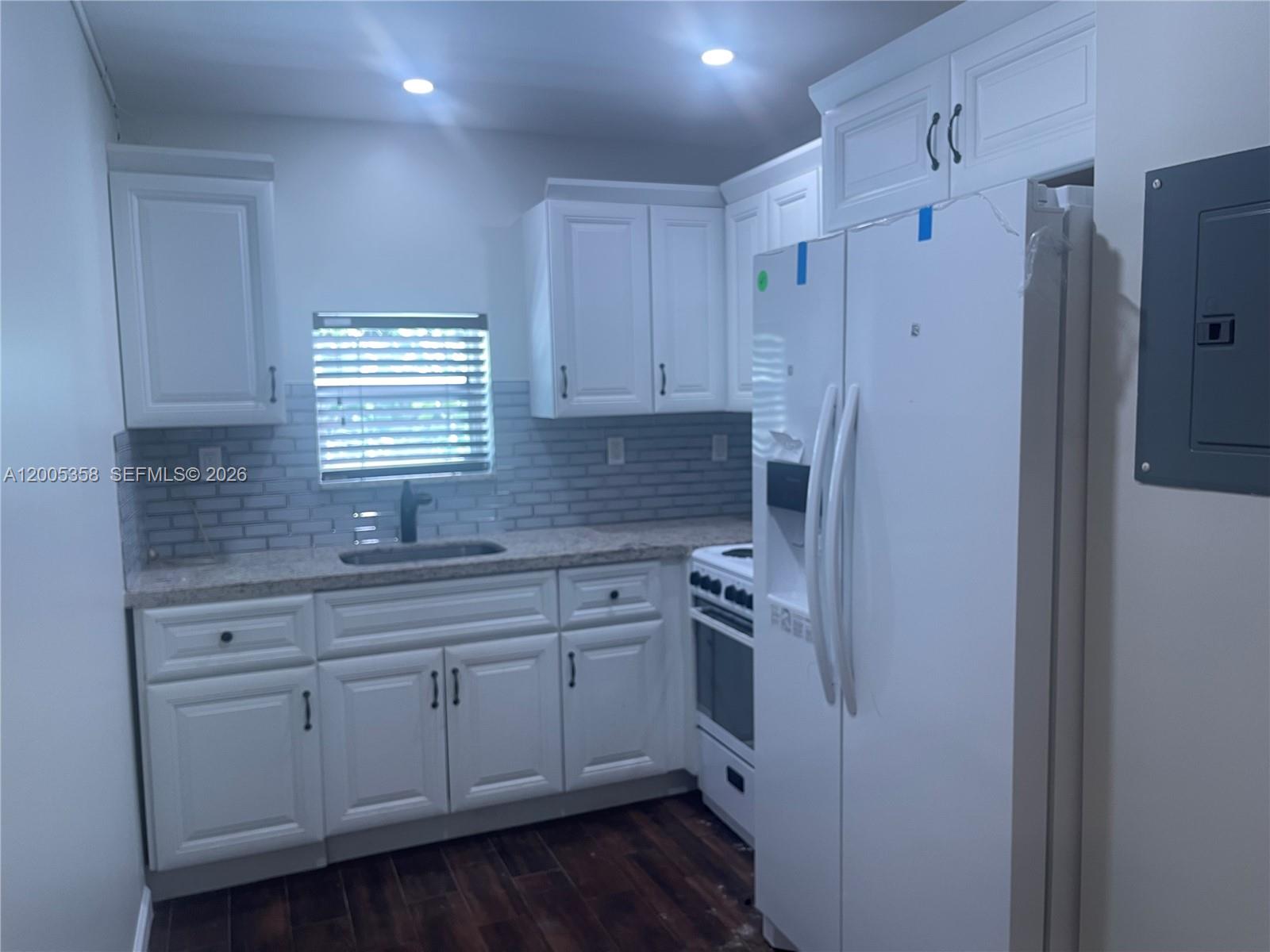 554 Northeast 74th Street, Unit 2 Miami, FL 33138 - Photo 4 of 30 a kitchen with white cabinets and white appliances