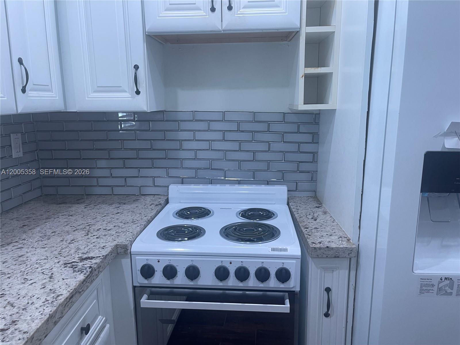 554 Northeast 74th Street, Unit 2 Miami, FL 33138 - Photo 5 of 30 a kitchen with a stove and cabinets