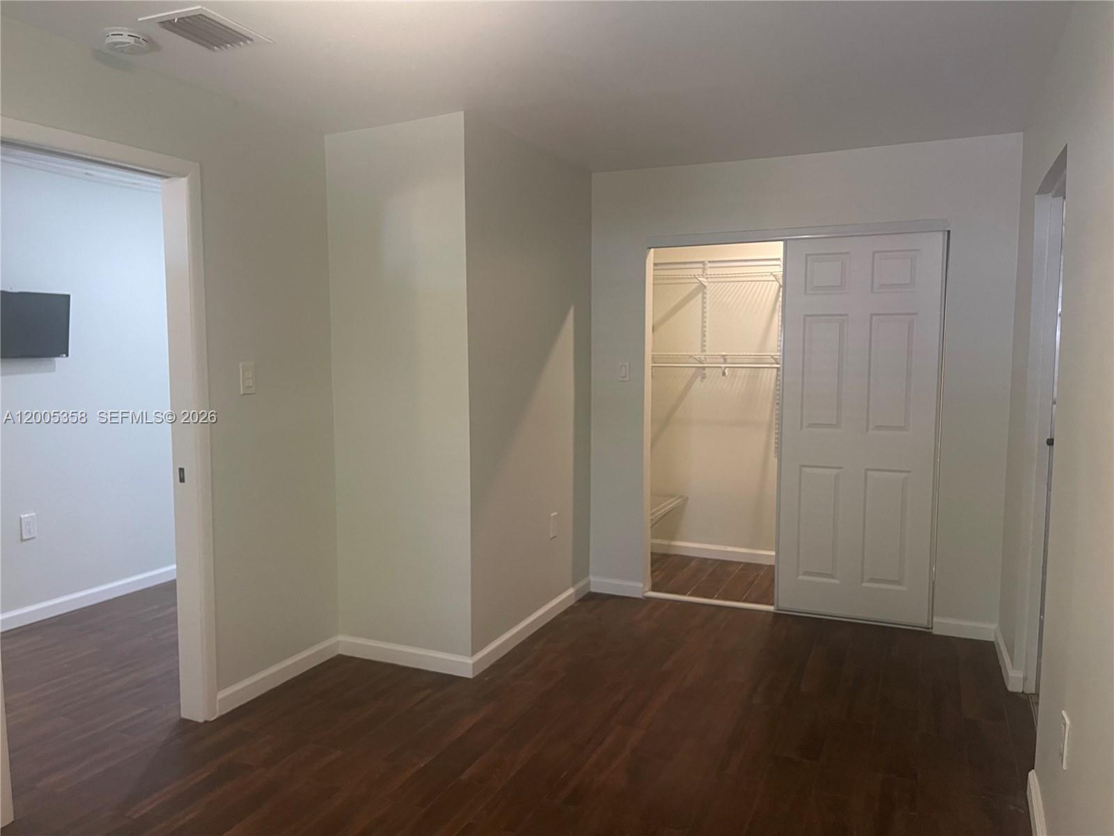 554 Northeast 74th Street, Unit 2 Miami, FL 33138 - Photo 7 of 30 an empty room with wooden floor and closet