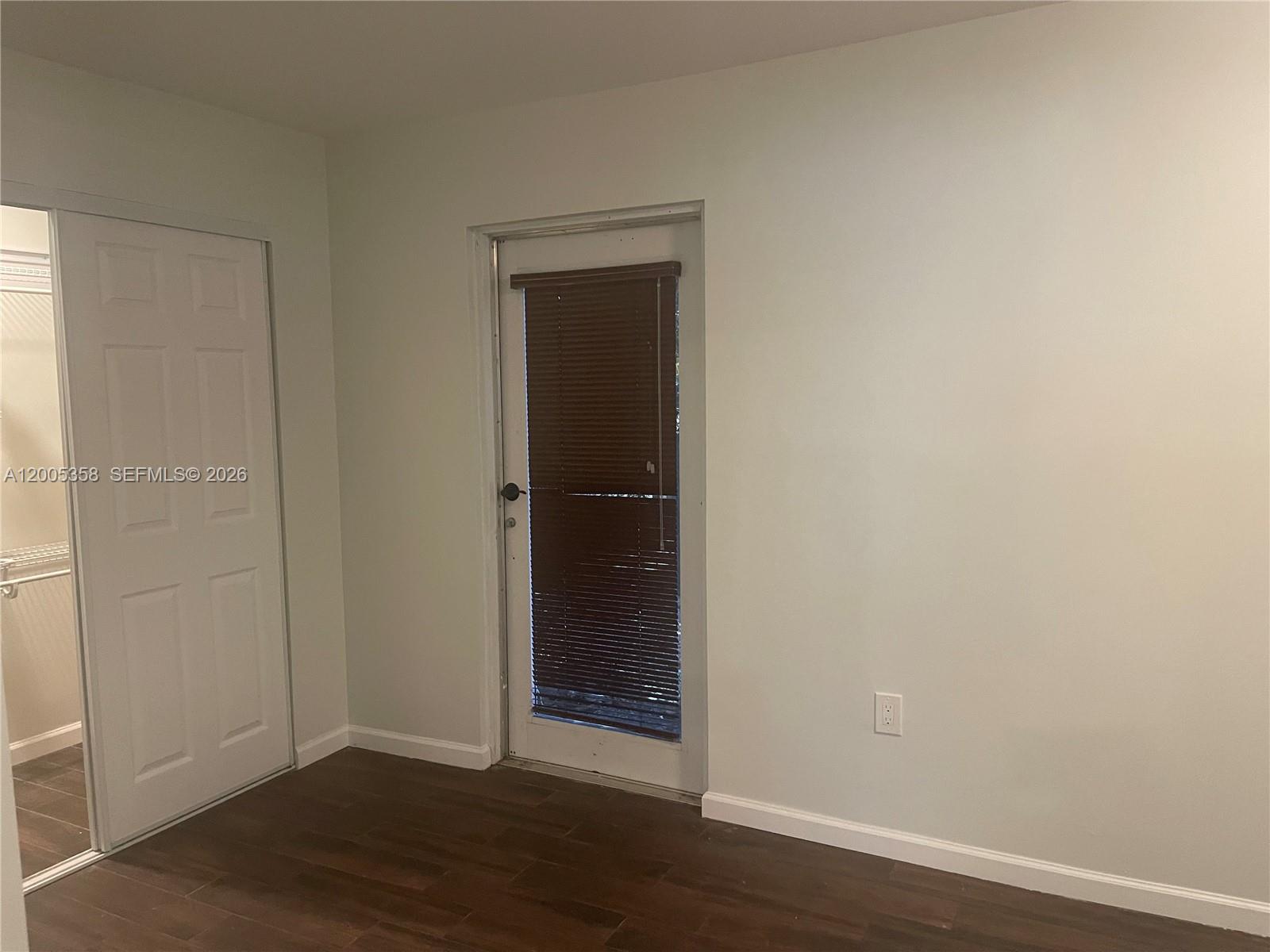 554 Northeast 74th Street, Unit 2 Miami, FL 33138 - Photo 8 of 30 an empty room with wooden floor and closet