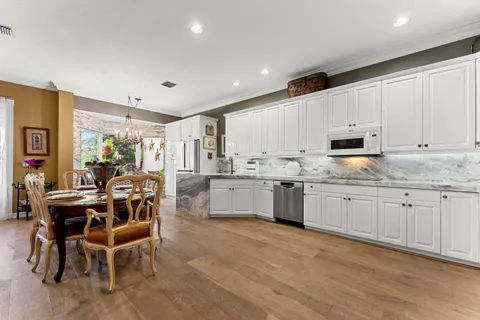 a kitchen with granite countertop white cabinets a counter top space and stainless steel appliances