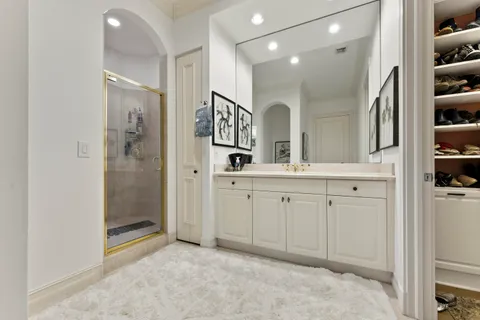 a spacious bathroom with a shower a sink and a mirror