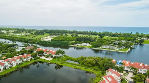 an aerial view of residential houses with outdoor space and lake view