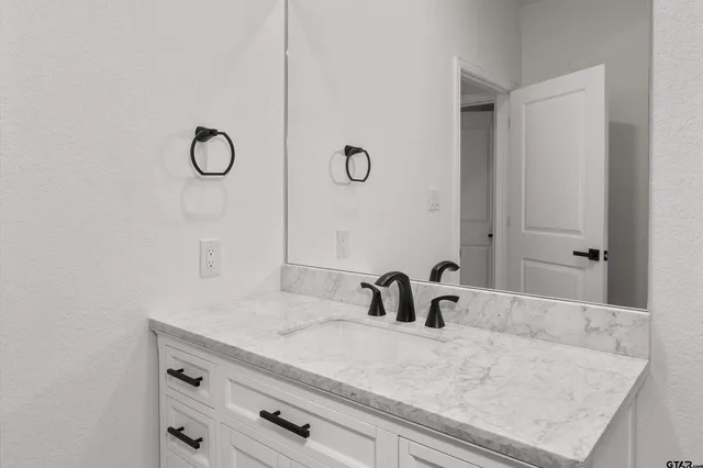 a bathroom with a sink vanity and mirror