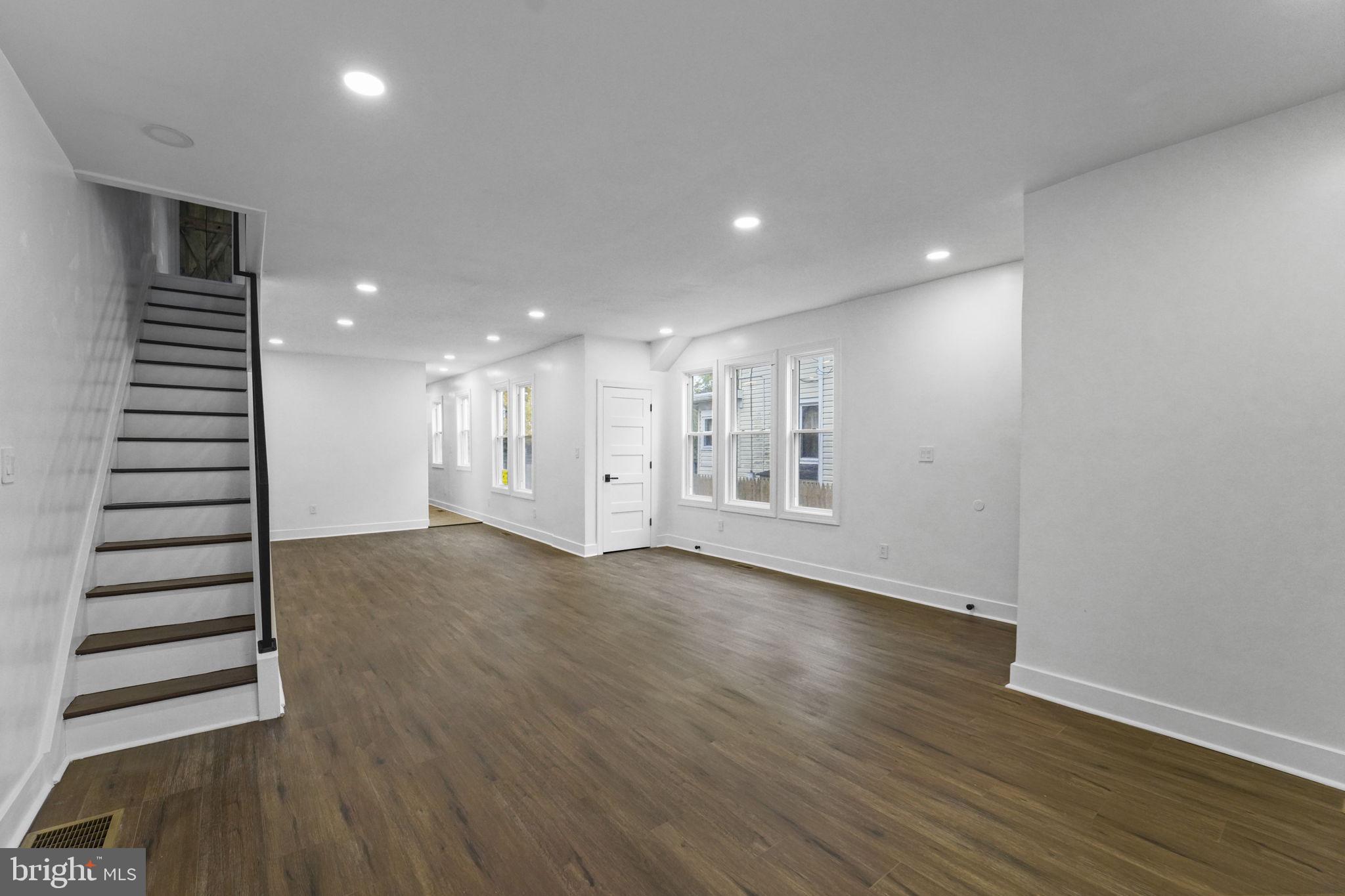 121 Parker Place Hamilton, NJ 08609 - Photo 8 of 37 an empty room with wooden floor windows and stairs