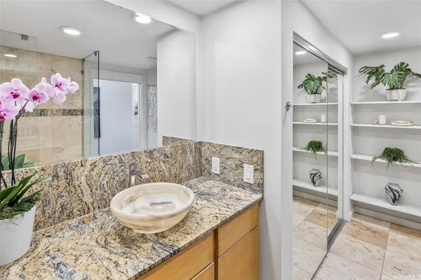 a bathroom with a granite countertop sink a toilet and a shower