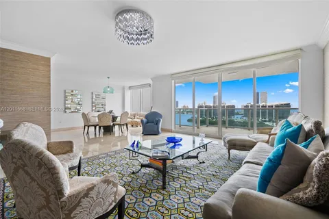 a living room with furniture a rug and a floor to ceiling window