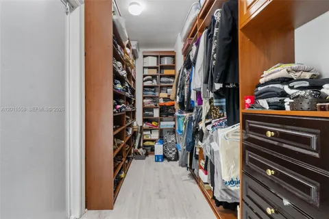 a view of walk in closet with clothes and shoes