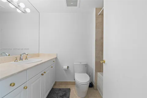 a bathroom with a granite countertop toilet and sink