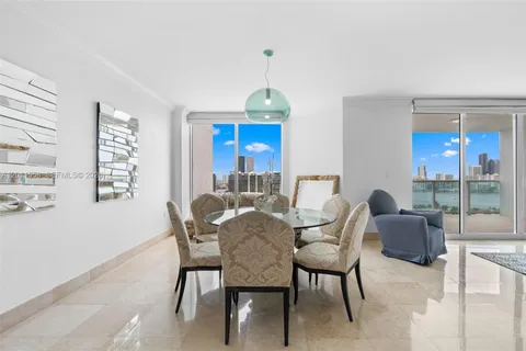 a dining room with furniture a chandelier and window