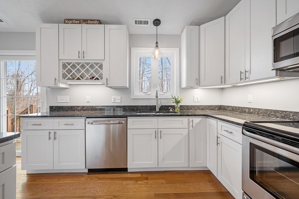 117 Shepard Road Sturbridge, MA 01566 - Photo 8 of 38 a kitchen with stainless steel appliances granite countertop a stove a sink and white cabinets