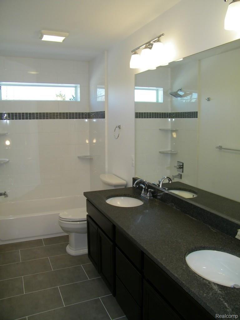 5415 Inverrary Lane Commerce Township, MI 48382 - Photo 16 of 18 UPPER LEVEL MAIN BATH: GRANITE COUNTERTOP VANITY, DOUBLE SINKS, GORGEOUS TILED TUB/SHOWER, CERAMIC TILE FLOOR.