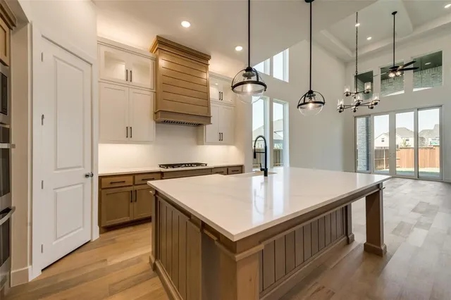 a kitchen with a stove a refrigerator a sink and wooden floor