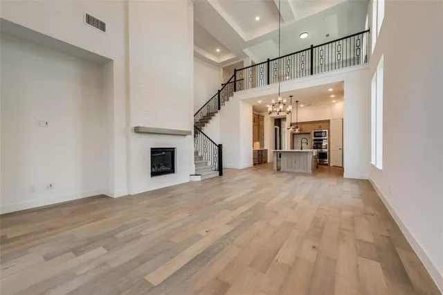 a view of empty room with wooden floor and fireplace