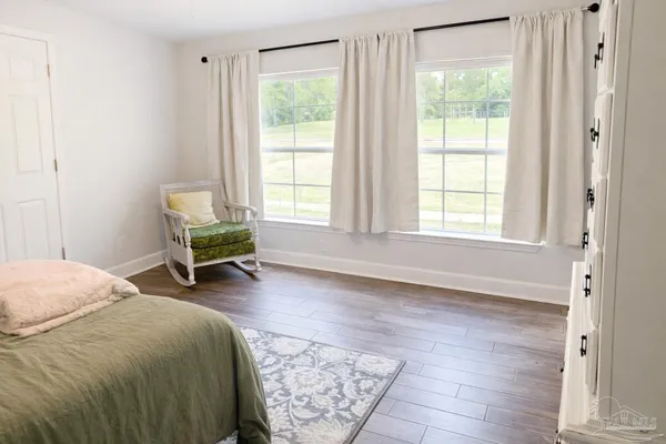 a spacious bedroom with a bed a table and a window