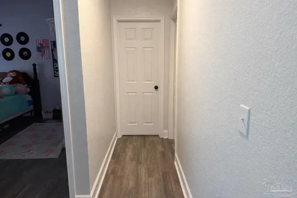 a view of a hallway with wooden floor and closet