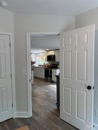 a view of a kitchen with a refrigerator a stove top oven cabinets