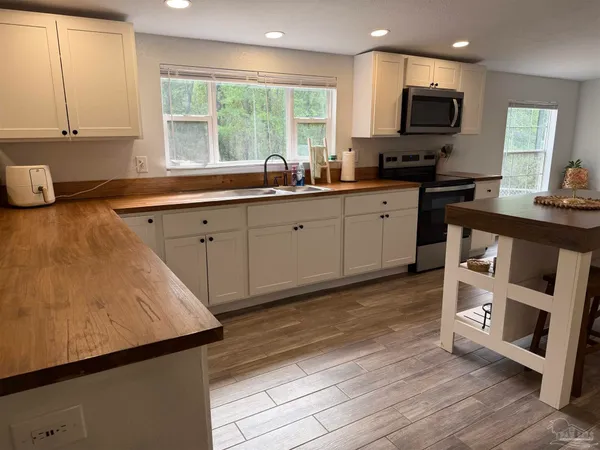 a kitchen with stainless steel appliances a stove sink and microwave