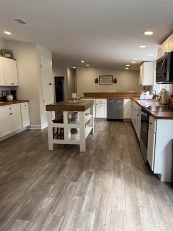 a kitchen with stainless steel appliances kitchen island granite countertop a stove a sink and a refrigerator