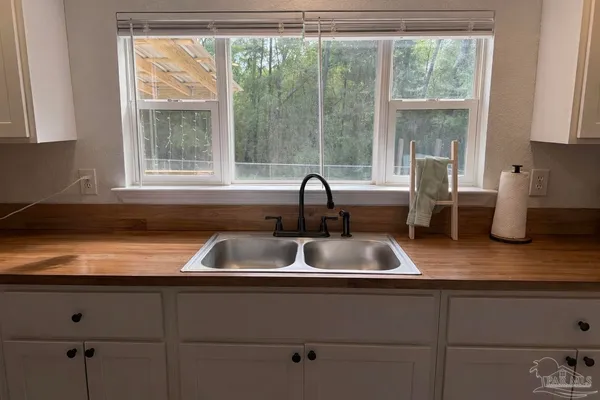 a kitchen with a sink cabinets and a large window