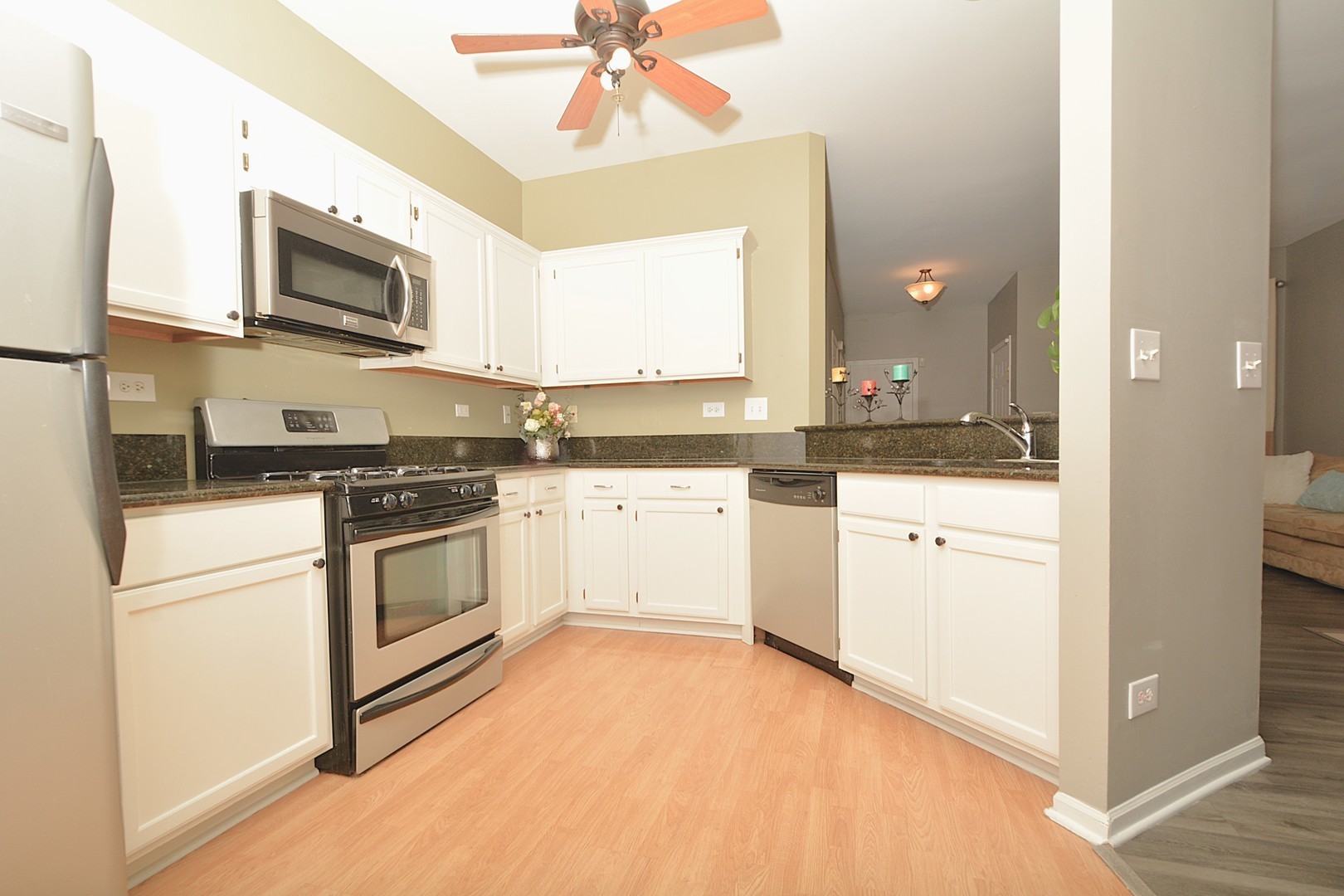 2974 Waters Edge Circle Aurora, IL 60504 - Photo 6 of 13 a kitchen with granite countertop white cabinets and white appliances