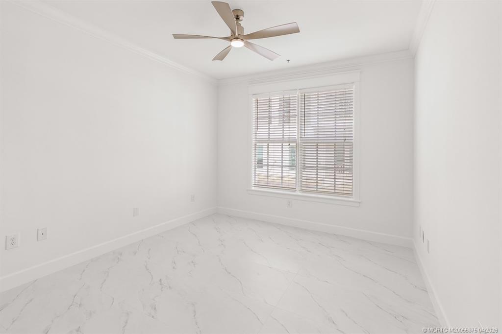 47 Southwest Osceola Street, Unit UN206 Stuart, FL 34994 - Photo 15 of 43 an empty room with chandelier fan and windows