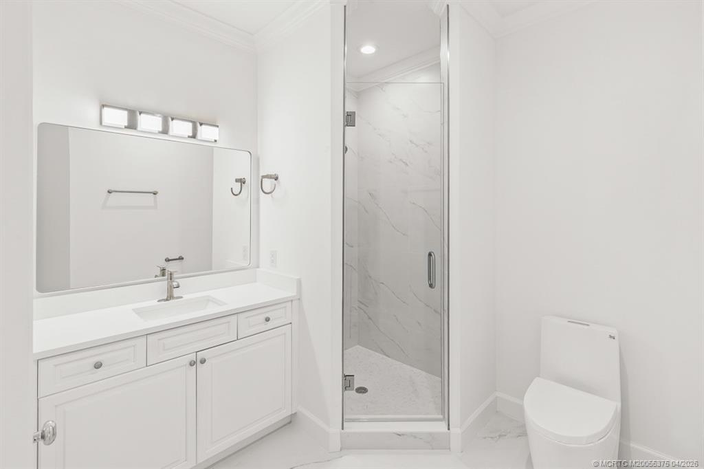 47 Southwest Osceola Street, Unit UN206 Stuart, FL 34994 - Photo 20 of 43 a bathroom with a shower sink vanity mirror and toilet