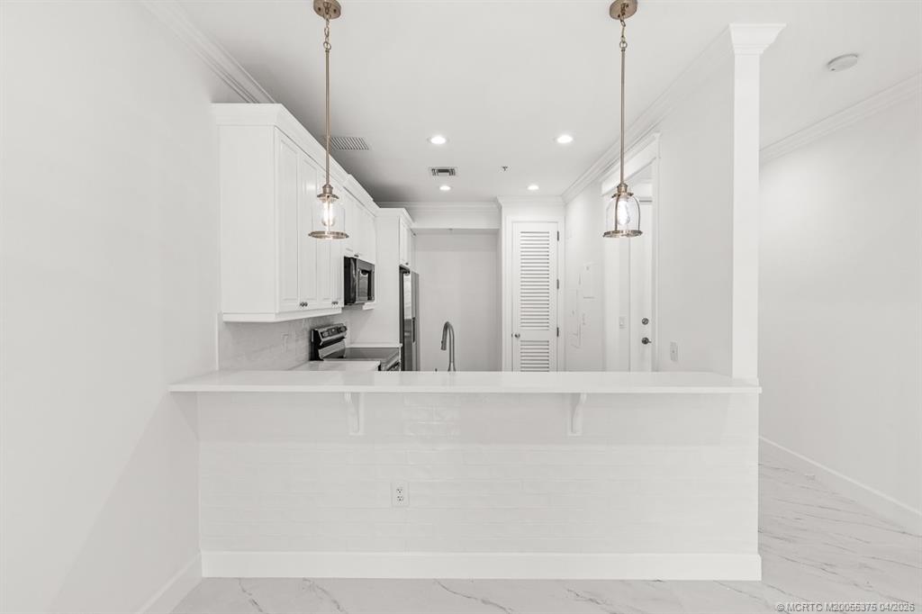 47 Southwest Osceola Street, Unit UN206 Stuart, FL 34994 - Photo 5 of 43 a view of a kitchen with a sink and a chandelier