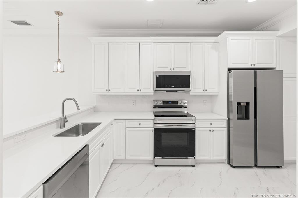 47 Southwest Osceola Street, Unit UN206 Stuart, FL 34994 - Photo 7 of 43 a kitchen with stainless steel appliances a refrigerator sink and white cabinets