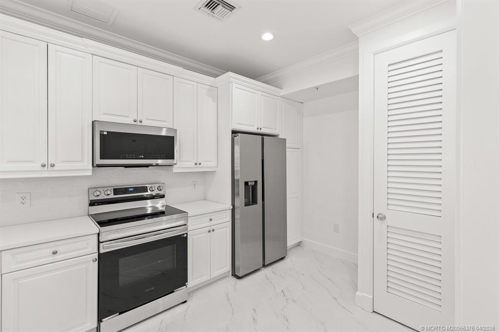 47 Southwest Osceola Street, Unit UN206 Stuart, FL 34994 - Photo 8 of 43 a kitchen with a stove and a microwave