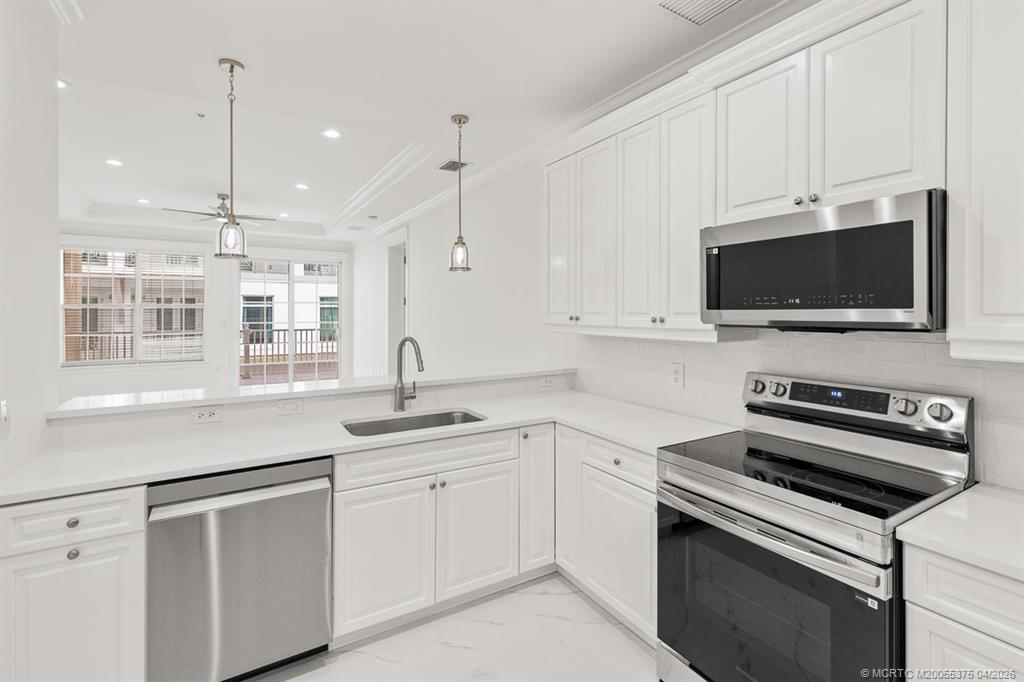 47 Southwest Osceola Street, Unit UN206 Stuart, FL 34994 - Photo 10 of 43 a kitchen with a sink stove and microwave