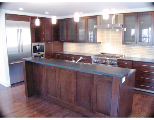 19 Roberts Road, Unit 19 Cambridge, MA 02138 - Photo 2 of 5 a kitchen with kitchen island granite countertop a sink and wooden cabinets