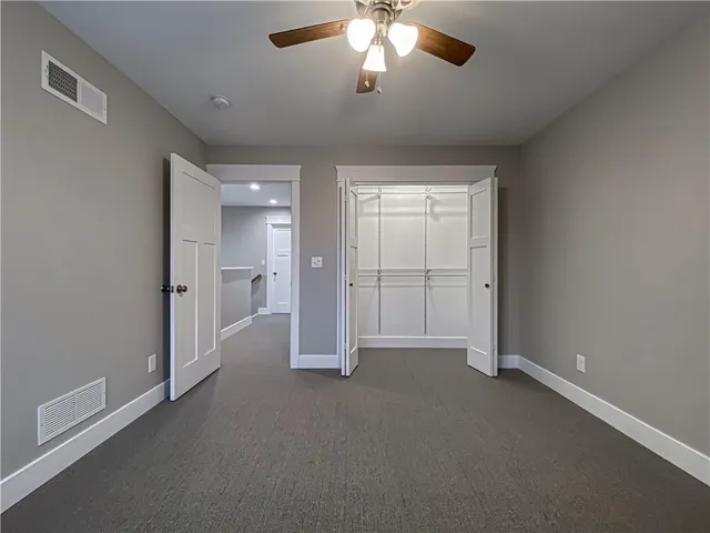 an empty room with fan and entrance