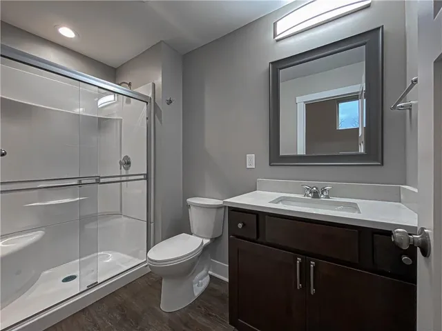 a bathroom with a sink toilet a mirror and shower