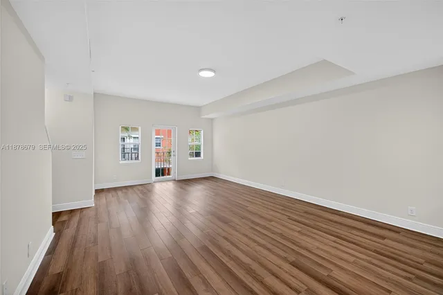 a view of a house with brick walls plants and large tree
