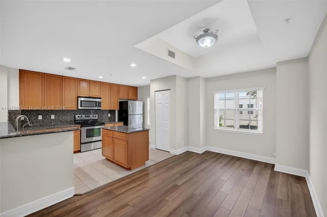 a kitchen with a refrigerator and a stove top oven