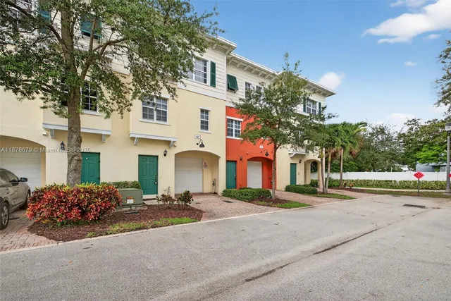 a front view of a house with a garden and trees