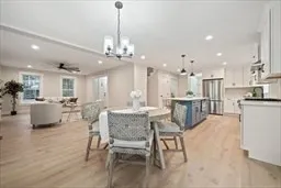 a view of a dining room and livingroom with furniture a chandelier