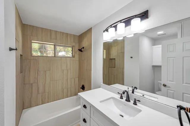 a bathroom with a sink a mirror and a bathtub