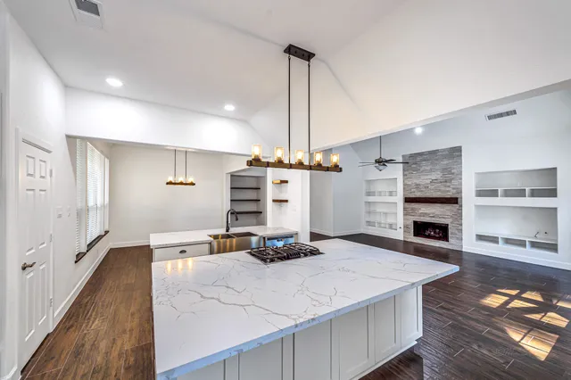 a kitchen with a stove a refrigerator and a fireplace