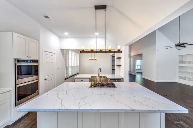 a kitchen with kitchen island a counter space a sink appliances and cabinets