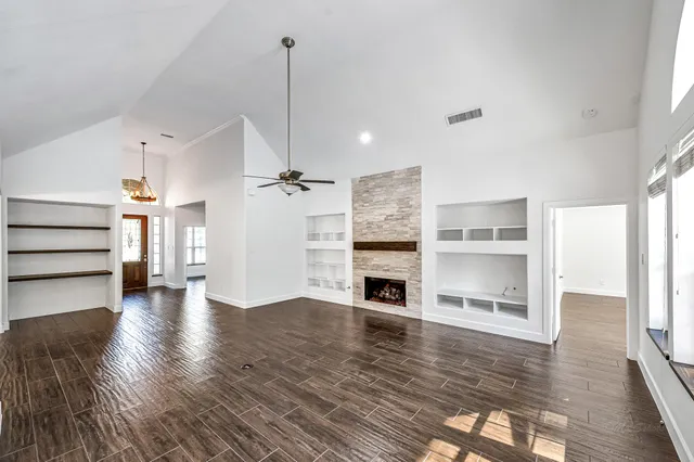 a view of empty room with wooden floor and fireplace