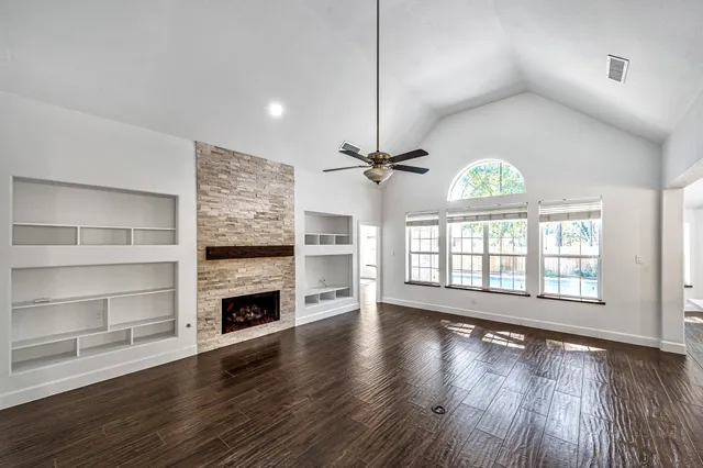 a view of an empty room with a fireplace and a window