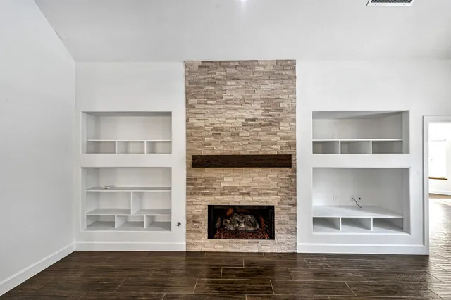 a view of an empty room with a fireplace and a window