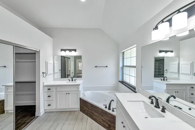 a bathroom with a tub sink and mirror