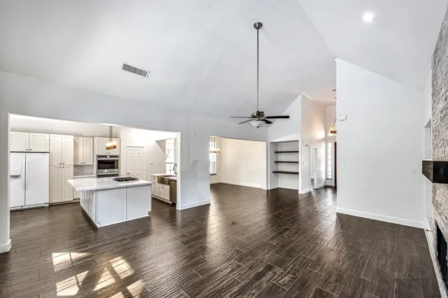 a view of a kitchen with a sink a stove and wooden floor