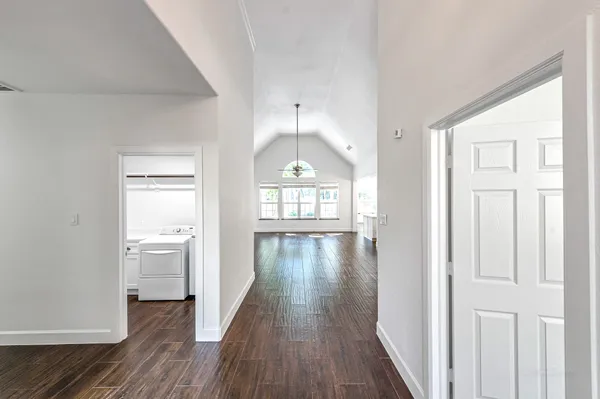 a view of a hallway with wooden floor and a living room
